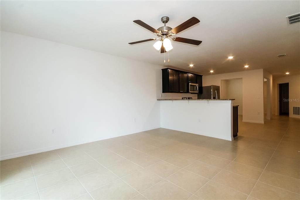 8615 Silverbell Loop Brooksville, FL 34613 - Photo 9 of 16 a view of a kitchen with a sink and a ceiling fan