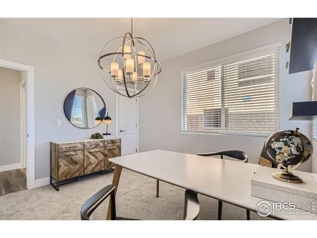 a dining room with wooden floor a chandelier a wooden table and chairs