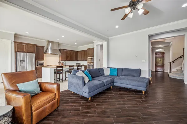 a living room with furniture and a view of kitchen