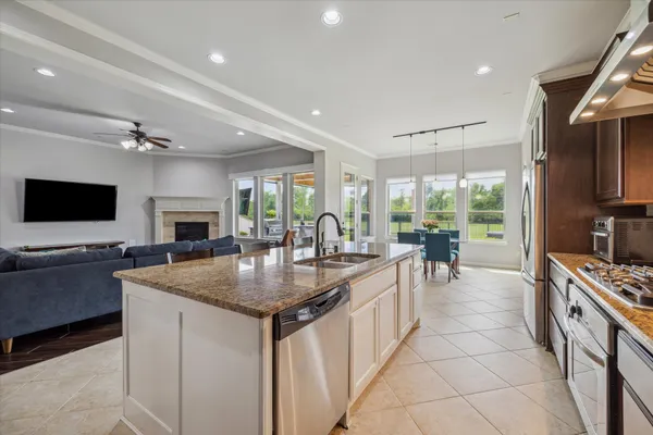 a kitchen with stainless steel appliances granite countertop a sink a stove and a refrigerator