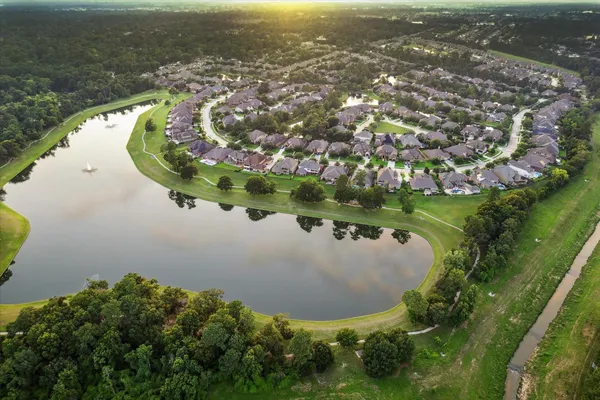an aerial view of a house with a yard and lake