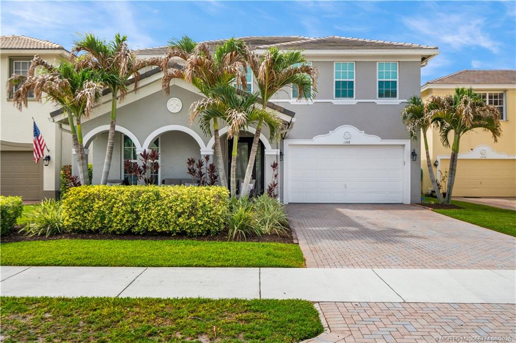 1268 Southeast Kirk Street Stuart, FL 34997 - Photo 1 of 63 a front view of a house with a garden