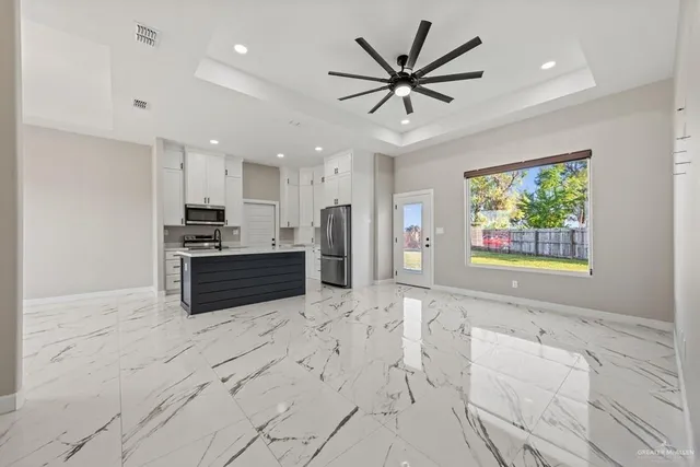 a large kitchen with stainless steel appliances kitchen island granite countertop a refrigerator a sink a stove a oven a dining table and chairs with wooden floor