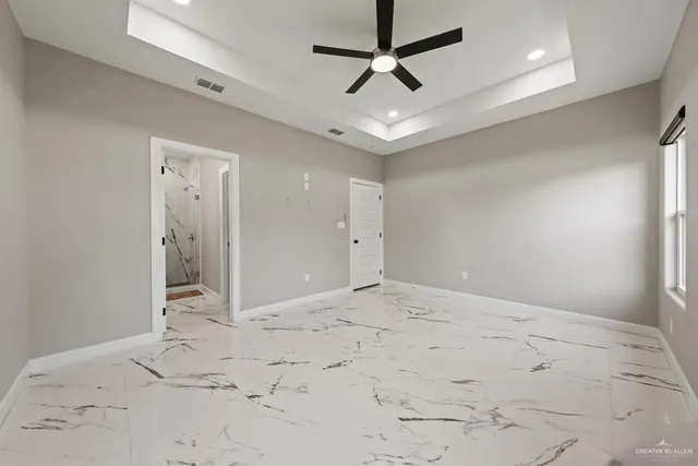 en empty space with a ceiling fan and a bathroom