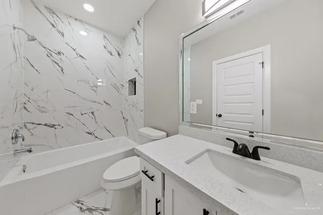a bathroom with a sink toilet vanity and bathtub
