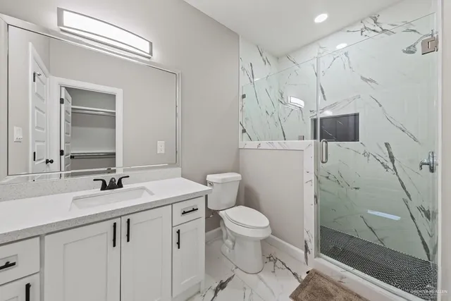 a bathroom with a sink a toilet and shower