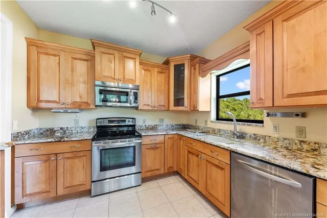 a kitchen with stainless steel appliances granite countertop a stove sink microwave and cabinets