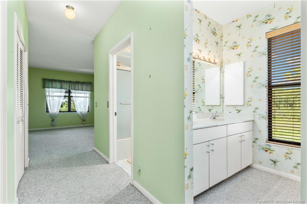 13464 Harbour Ridge Boulevard, Unit 8B Palm City, FL 34990 - Photo 16 of 33 a bathroom with a double vanity sink and mirror