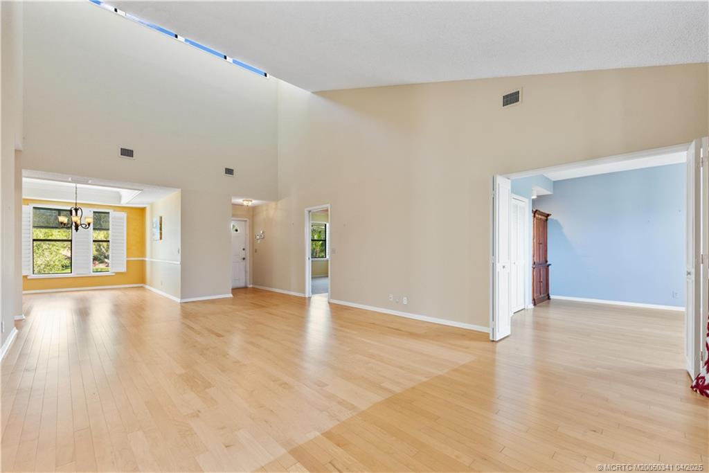 13464 Harbour Ridge Boulevard, Unit 8B Palm City, FL 34990 - Photo 6 of 33 a view of an empty room with wooden floor and a window