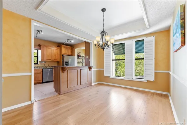 a kitchen with stainless steel appliances granite countertop a refrigerator a oven and a wooden floors