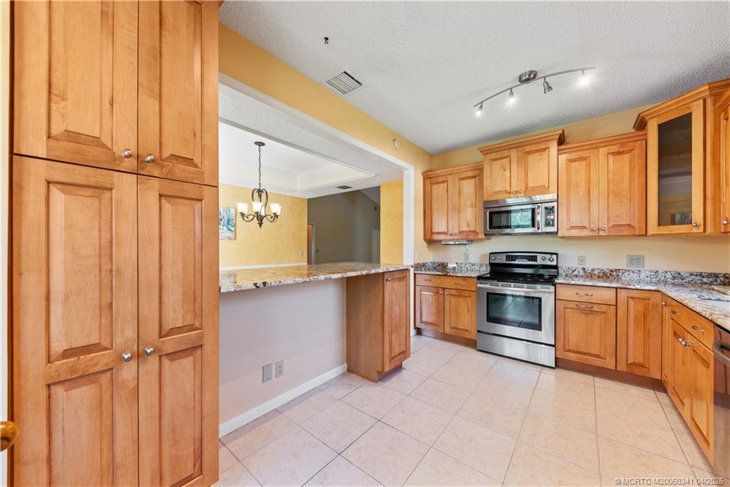 13464 Harbour Ridge Boulevard, Unit 8B Palm City, FL 34990 - Photo 9 of 33 a kitchen with stainless steel appliances a refrigerator and cabinets
