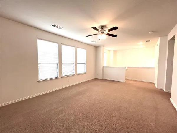an empty room with a ceiling fan and window