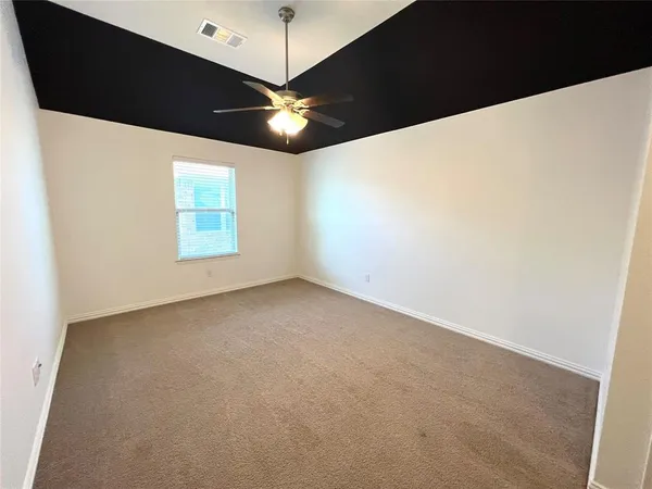 an empty room with a window and a fan