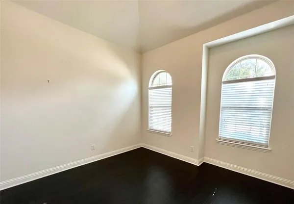 an empty room with wooden floor and a window