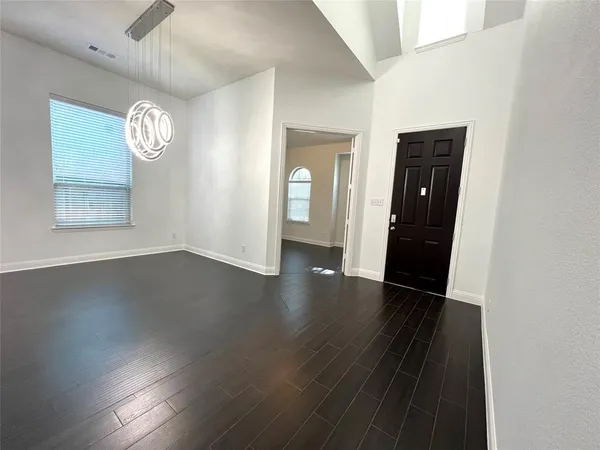 an empty room with wooden floor and a window