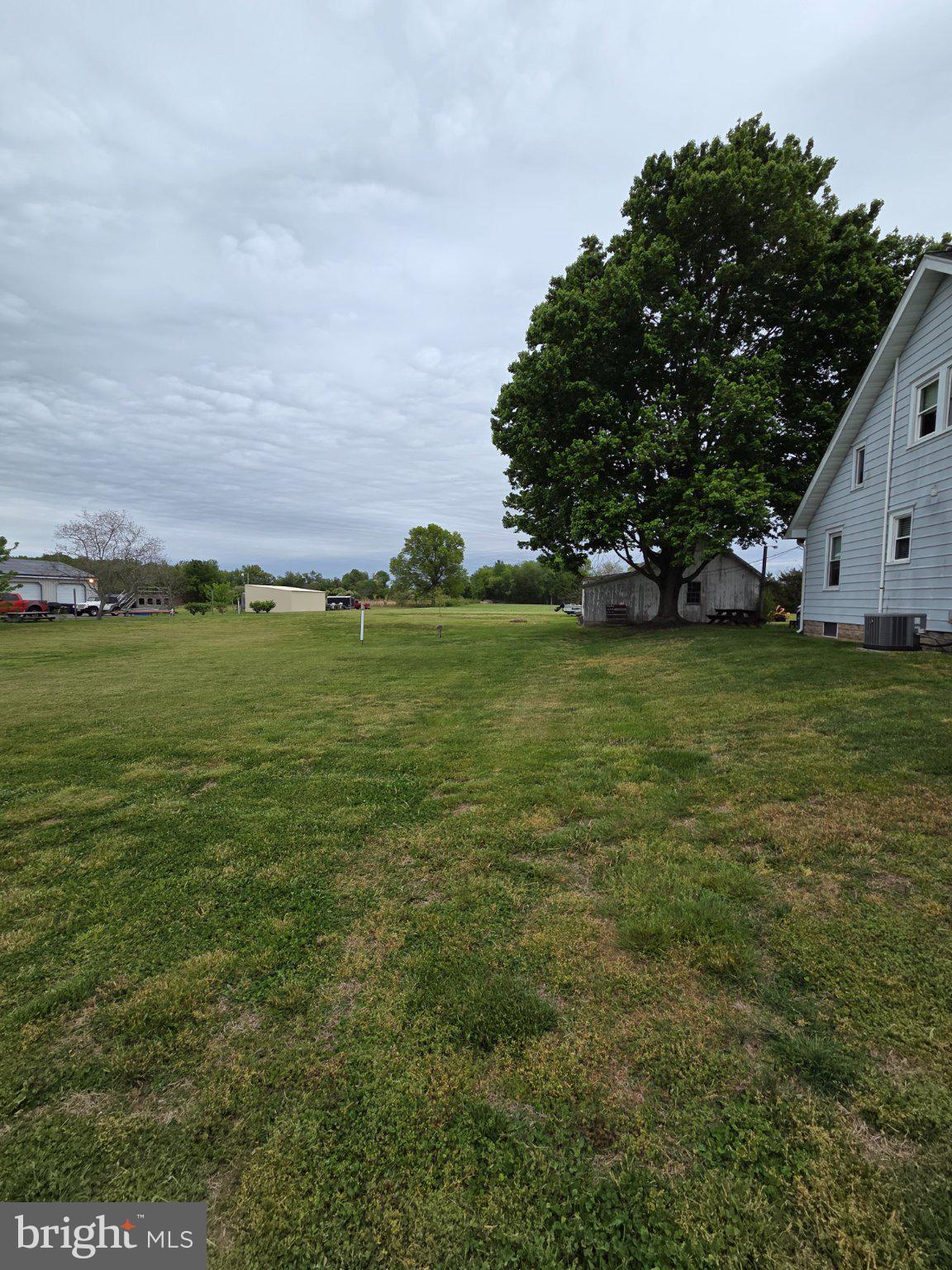 894 Main St - Canton Road Salem, NJ 08079 - Photo 17 of 17 Spacious yard under a cloudy sky.