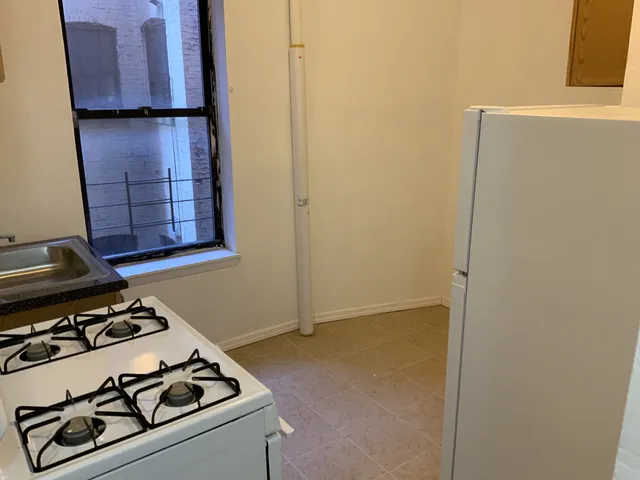a white refrigerator freezer and a stove sitting inside of a kitchen