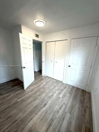 an empty room with wooden floor and white walls
