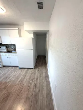a view of a kitchen with wooden floor and electronic appliances