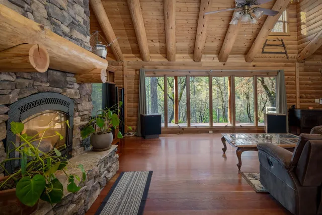 a living room with furniture fireplace and large windows