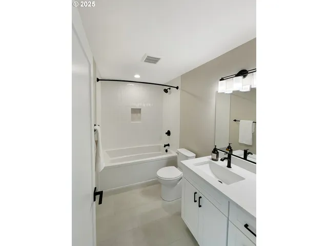 a bathroom with a double vanity sink toilet mirror and shower