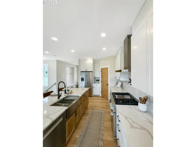 a large white kitchen with stainless steel appliances