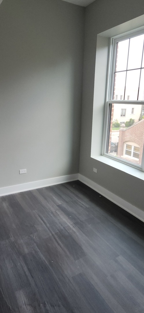 1023 East 45th Street, Unit 2 Chicago, IL 60653 - Photo 11 of 12 an empty room with wooden floor and windows