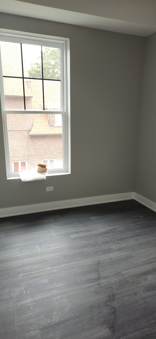 1023 East 45th Street, Unit 2 Chicago, IL 60653 - Photo 7 of 12 a view of a room with wooden floor and windows