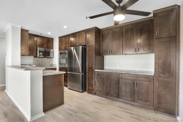 a kitchen with kitchen island a refrigerator and a sink