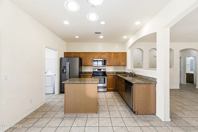a kitchen with stainless steel appliances a refrigerator sink and microwave