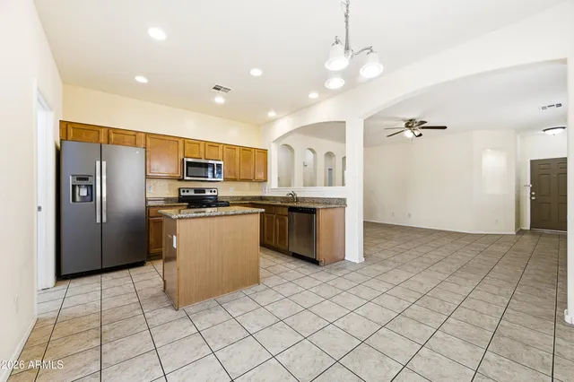 a kitchen with stainless steel appliances granite countertop a refrigerator and a stove top oven