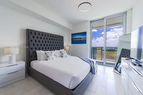 a bedroom with a large bed and a large window