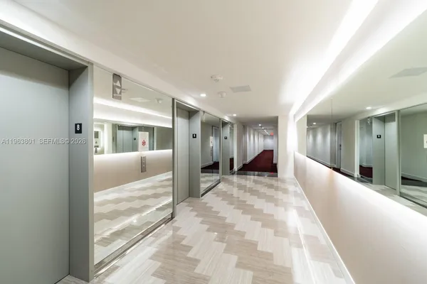 a view of a hallway with wooden floor and windows
