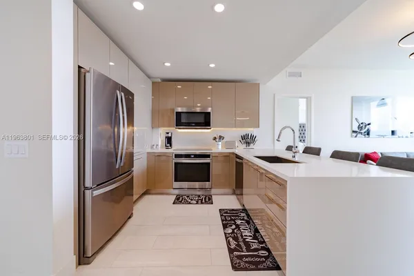 a kitchen with granite countertop a sink stainless steel appliances and white cabinets