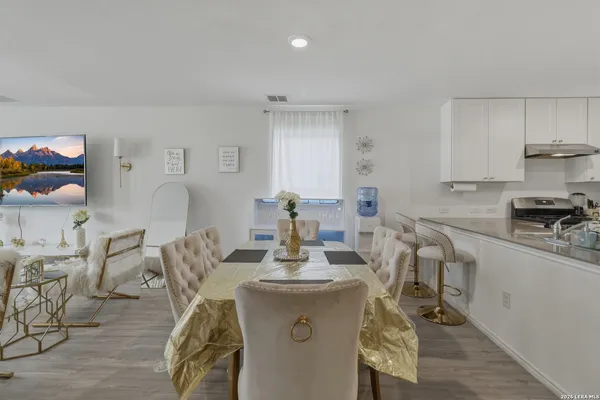 a kitchen with stainless steel appliances a table and chairs in it