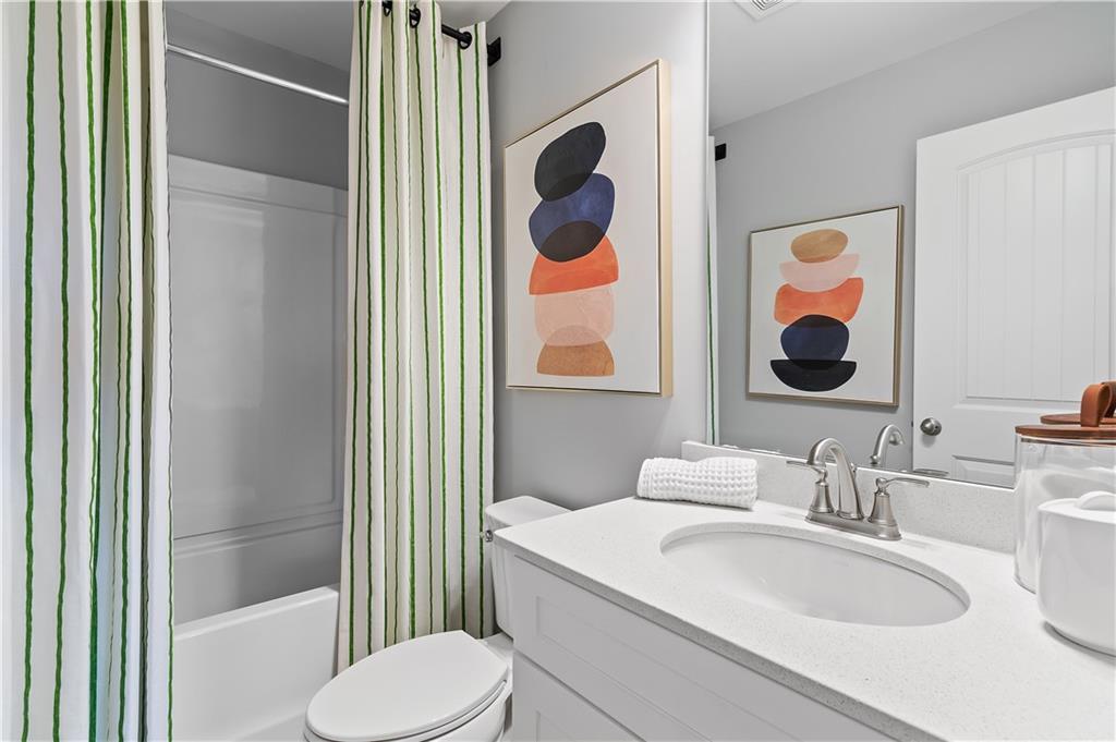 8203 Tiger Way Riverdale, GA 30296 - Photo 24 of 37 a bathroom with a granite countertop sink mirror vanity and toilet