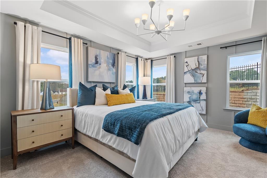 8203 Tiger Way Riverdale, GA 30296 - Photo 26 of 37 a bedroom with a large bed and a chandelier