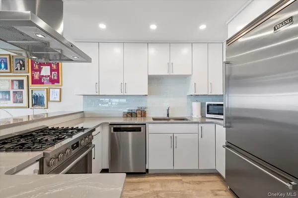 a kitchen with stainless steel appliances granite countertop a sink stove and refrigerator