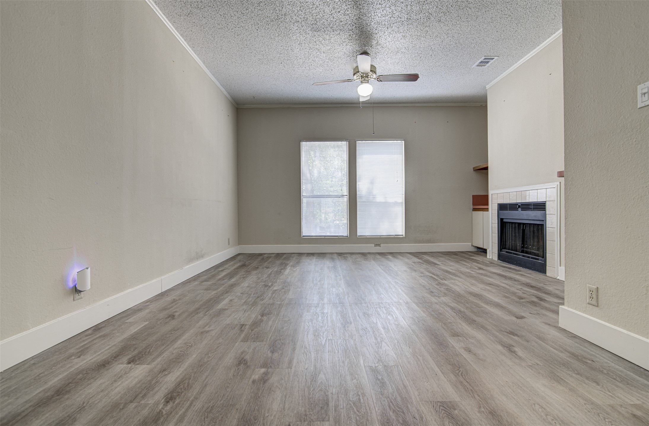 2804 Rio Grande Street, Unit 208 Austin, TX 78705 - Photo 7 of 24 Well-maintained flooring and a fireplace define this generous living space.
