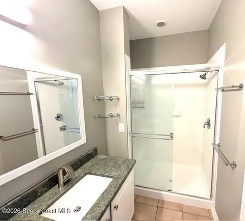 a bathroom with a granite countertop sink mirror and shower