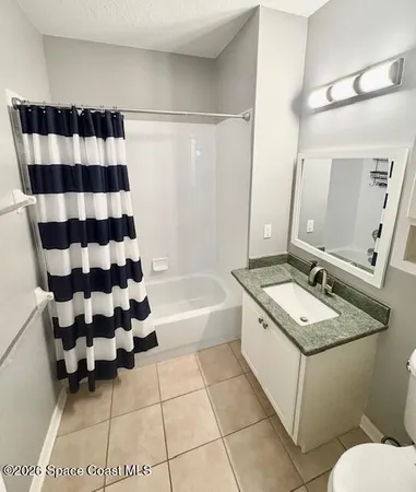 a bathroom with a sink a toilet a mirror and shower