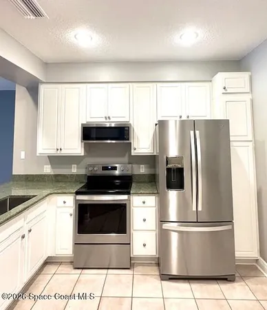 a kitchen with stainless steel appliances a refrigerator sink and microwave
