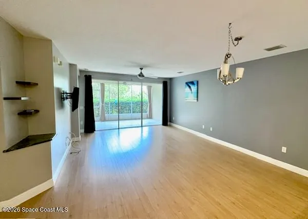 a view of a room with wooden floor and windows