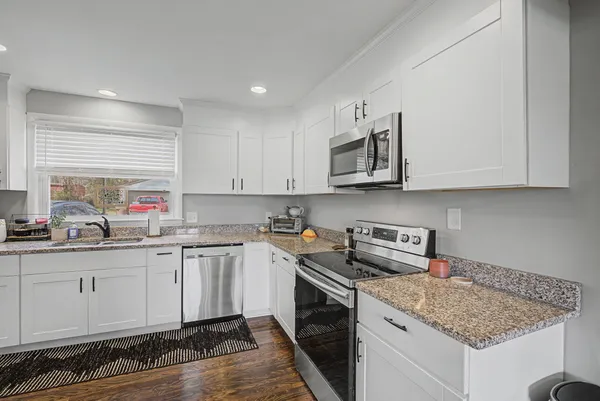 a kitchen with stainless steel appliances granite countertop a sink stove and cabinets