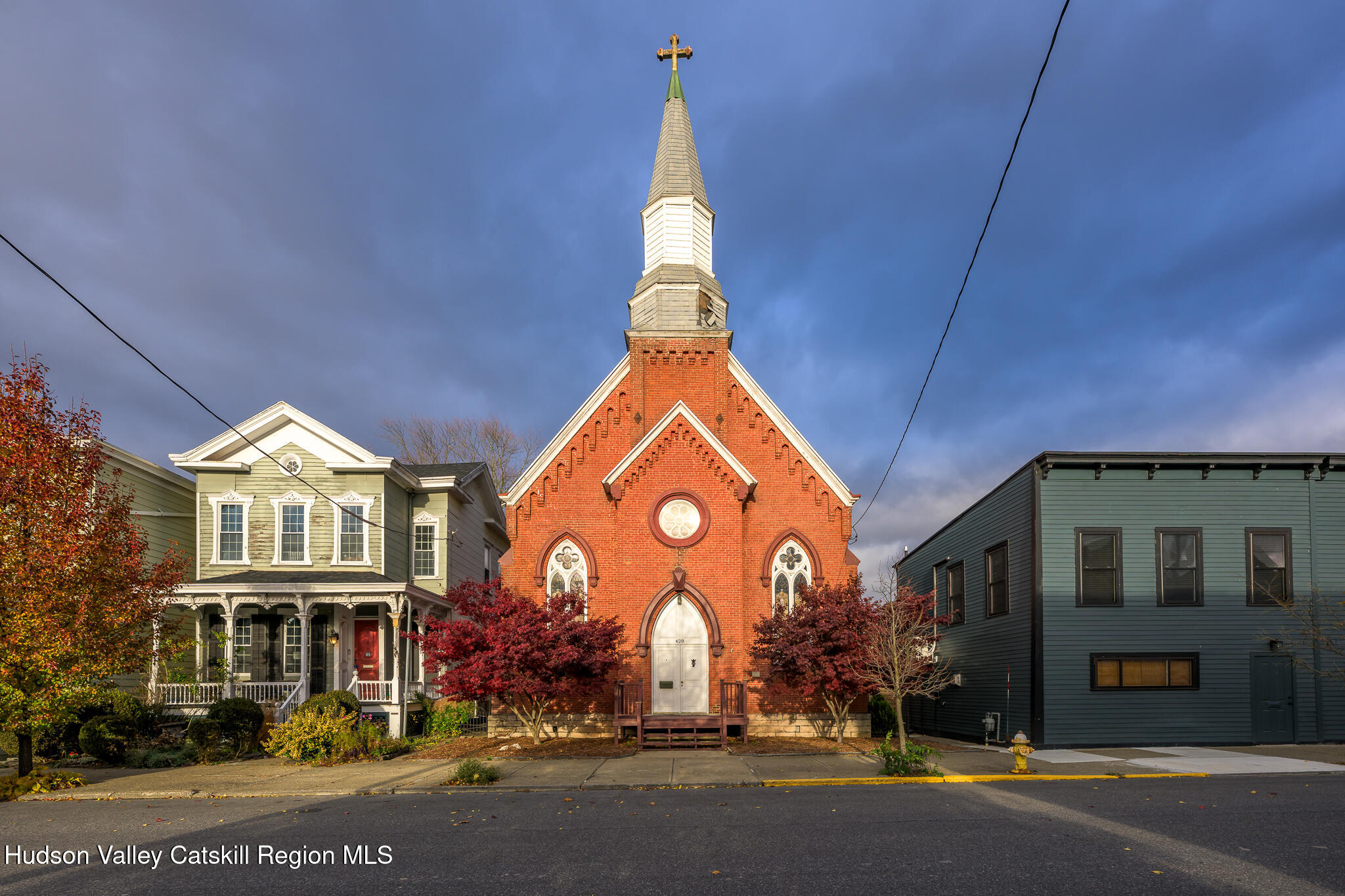 a view of a building with a clock tower in middle of a yard