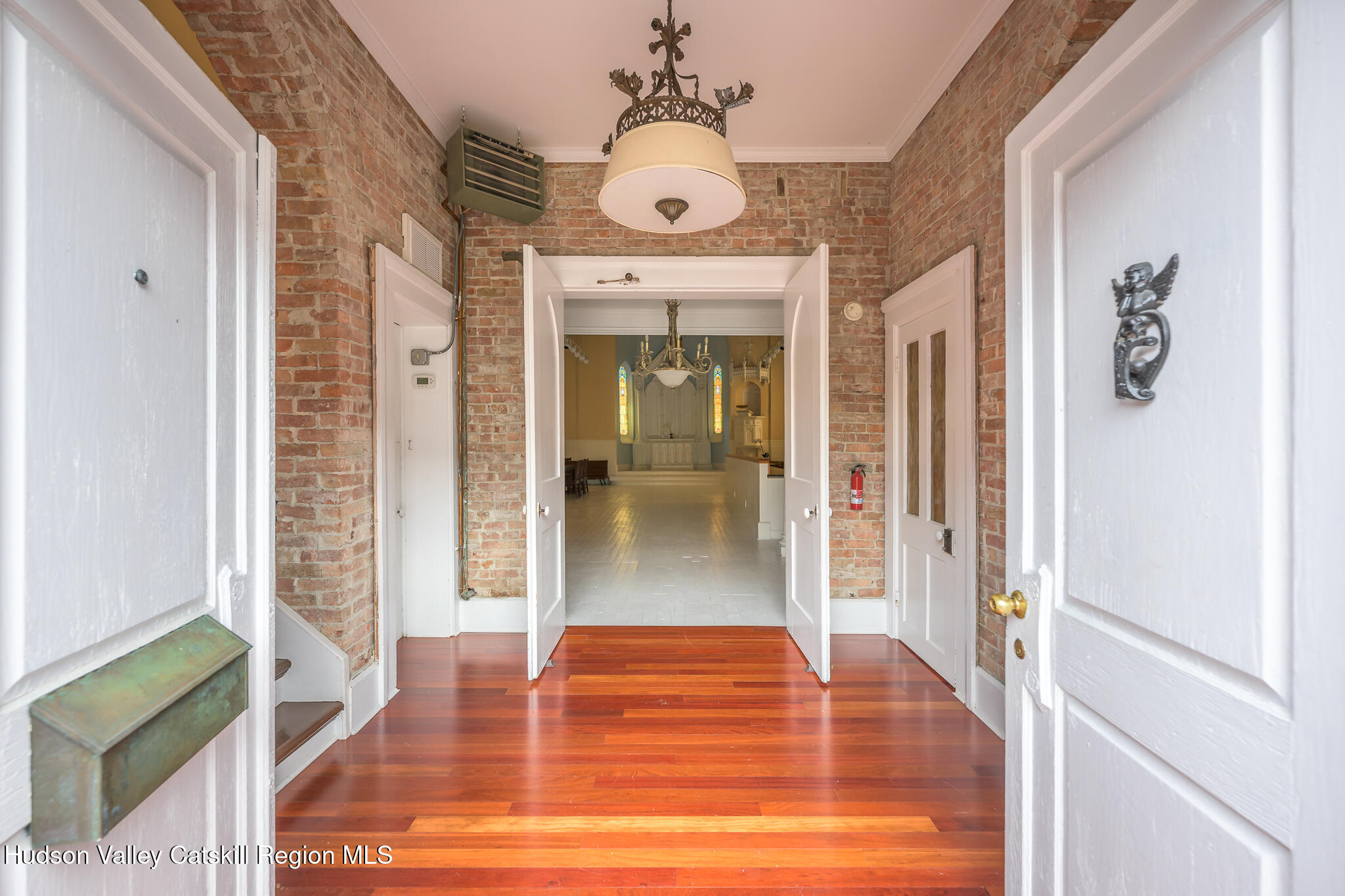428 State Street Hudson, NY 12534 - Photo 4 of 23 a view of a hallway with wooden floor and a living room