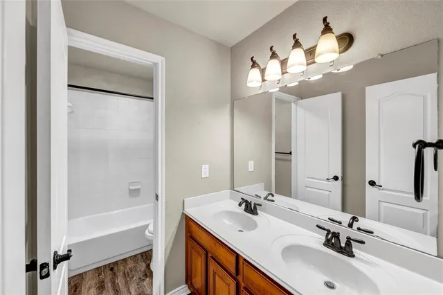 a bathroom with a sink a light fixture and a mirror