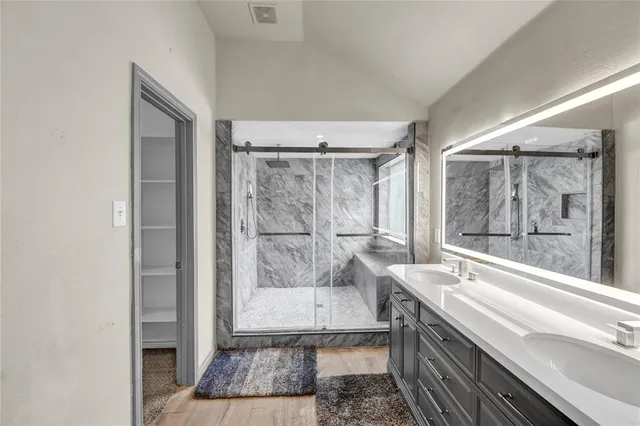 a bathroom with a granite countertop sink a mirror and a bathtub