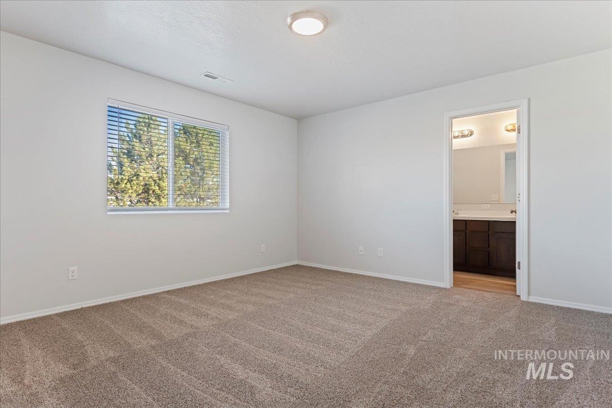 926 West Woodpine Street Meridian, ID 83646 - Photo 14 of 32 Unfurnished bedroom featuring light colored carpet and ensuite bath