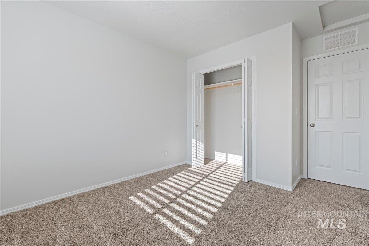 926 West Woodpine Street Meridian, ID 83646 - Photo 20 of 32 Unfurnished bedroom with light colored carpet and a closet